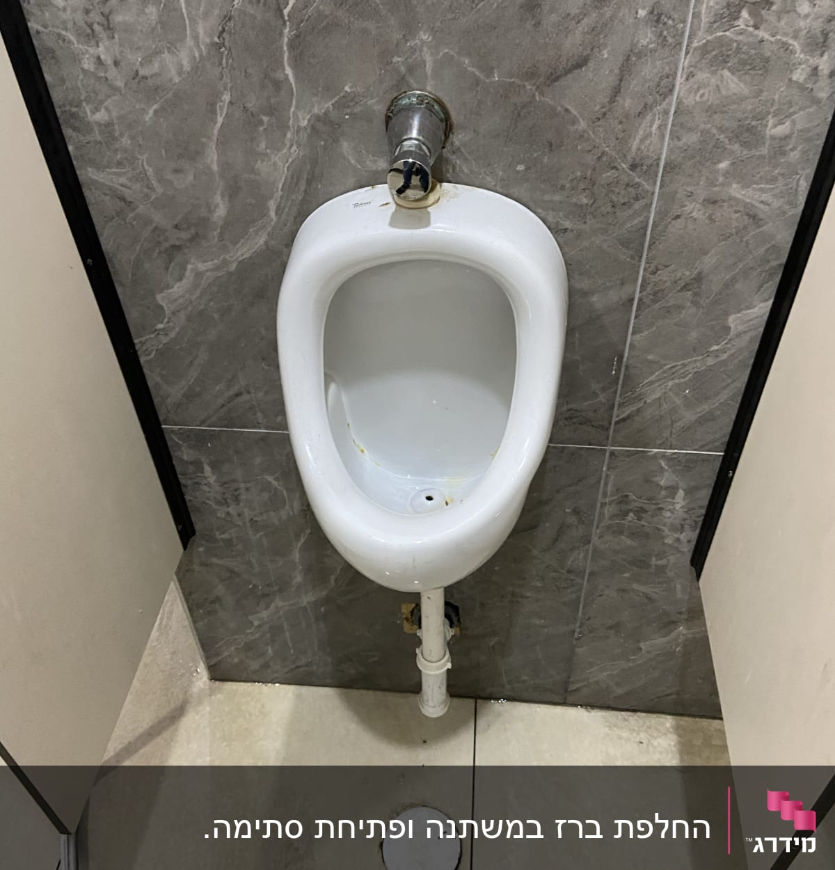 אסלה עם צינור ניקוז על קיר אריחים אפור